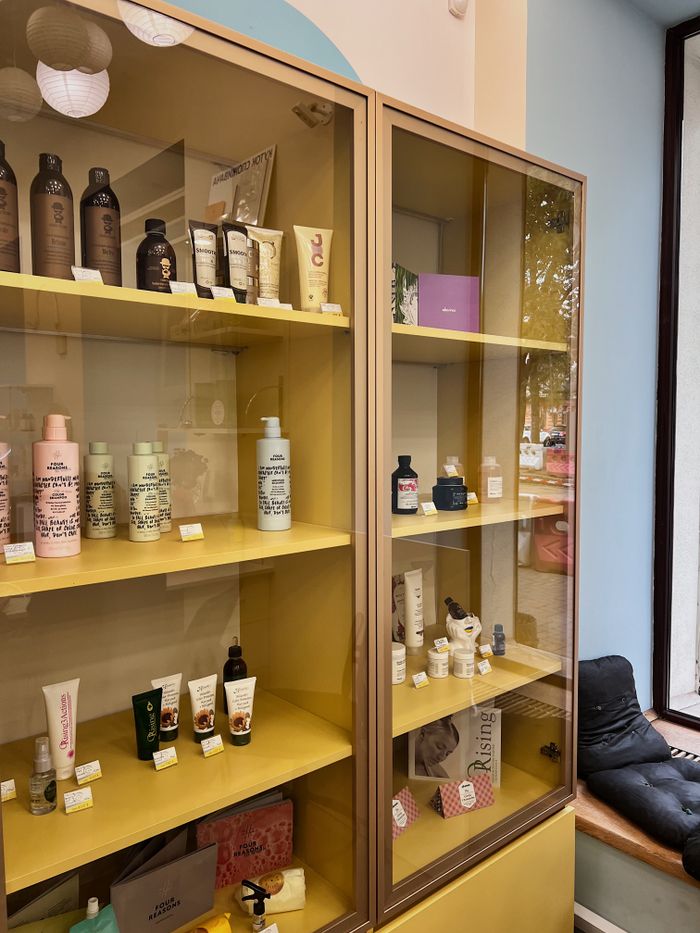 The Art of Drawing Readers In: Your attractive post title goes here Explore a colorful array of cosmetics elegantly showcased on vibrant yellow shelving indoors.