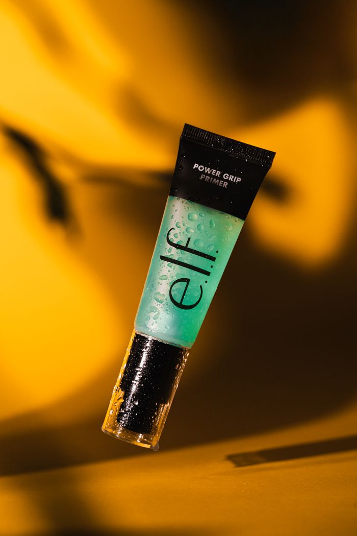 Mastering the First Impression: Your intriguing post title goes here Vibrant e.l.f. Power Grip Primer suspended against a rich golden background.